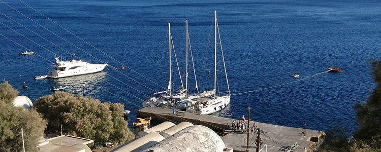 Яхты у пирса деревни Ия на острове Санторин. Киклады. Греция